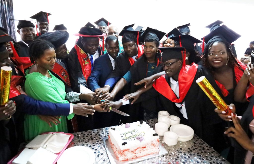 Members of the College management and graduands cutting the cake to symbolize the celebration.