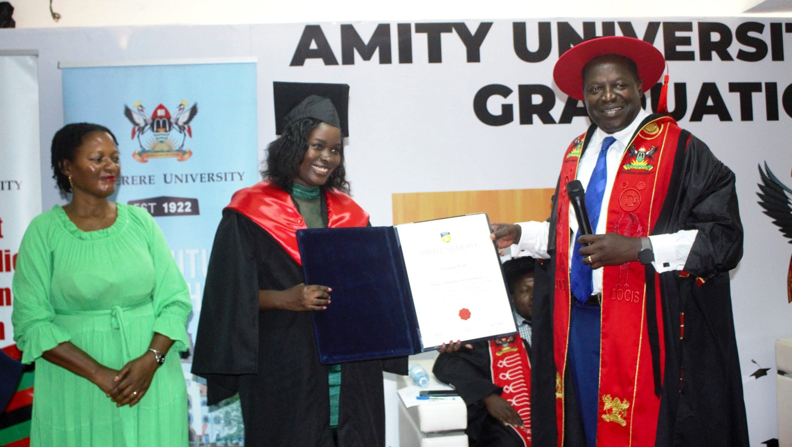 The Principal CoCIS, Prof. Tonny Oyana (Right) joined by the Head CIPSD-Ms. Barbara Nalubega (Left) presents a certificate to one of the over 300 graduands who pursued education under the auspices of the Makerere-Amity and e-VBAB Project during the award ceremony held on 14th April 2023 at CoCIS, Makerere University.