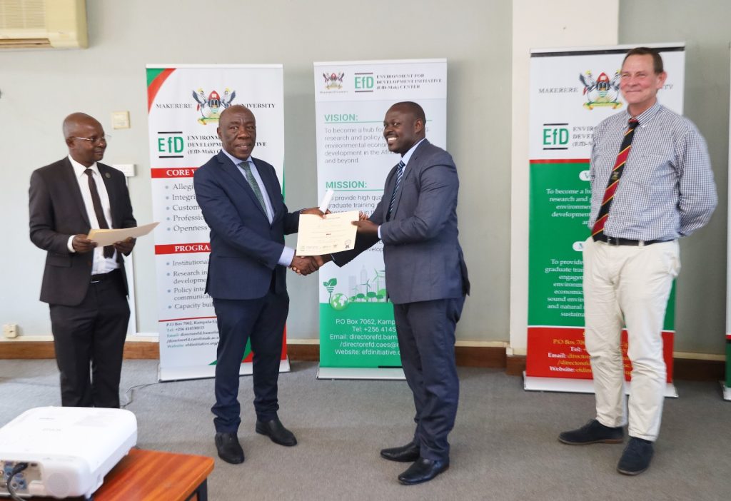 One of the participants receiving the certificate from Prof. Henry Alinaitwe (2nd Left)  as Prof. Edward Bbaale (Left) and Prof. Anders Ekbong (Right) witness.