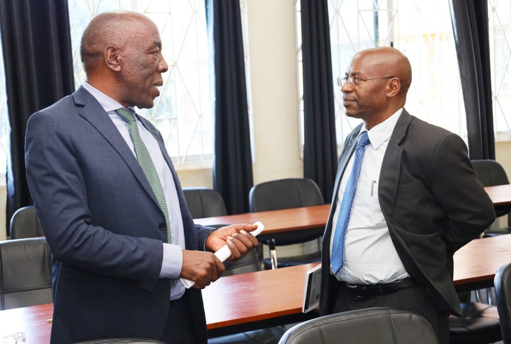 Eng. Prof. Henry Alinaitwe (Left) interacts with EfD Mak's Deputy Director Prof. Johnny Mugisha (Right).