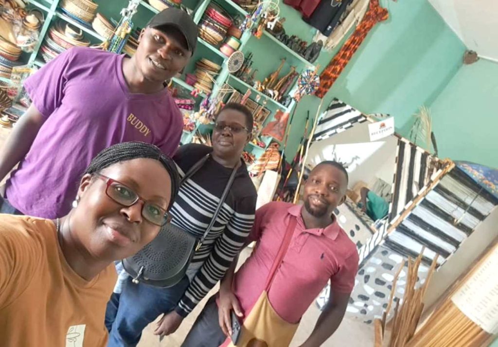 Dr. Kellen Aganyira (Foreground) with L-R: Mr. Denis Ntende, Ag. Dean SoDLL-Dr. Constance Mudondo and Mr. Jordan Lwanga Byekwaso pose for a group photo in the Bigodi Community Craft shop. 