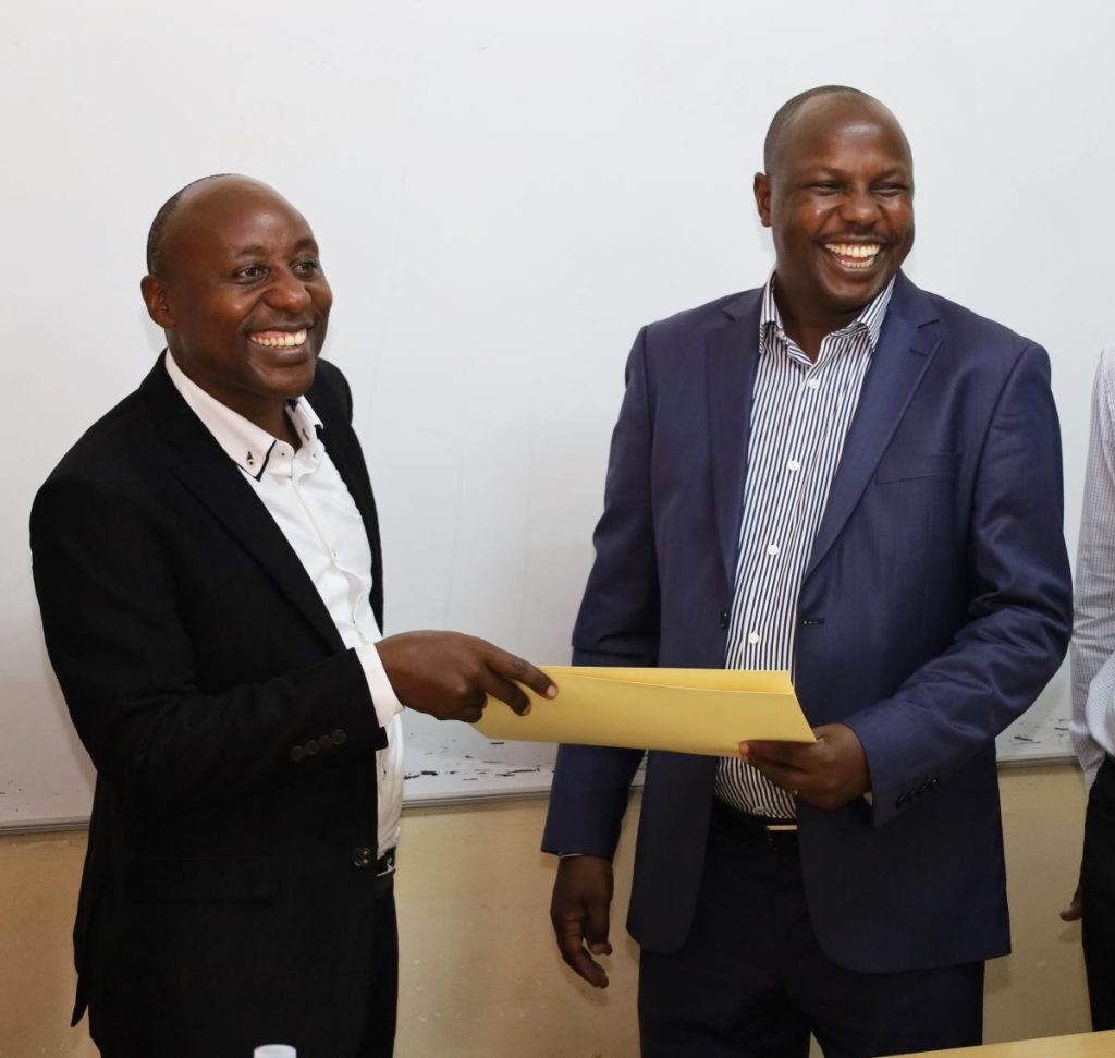 Prof. Eddy Walakira (Left) hands over his report to Dr. Denis Muhangi (Right), SWASA, CHUSS, Makerere University, Kampala Uganda.