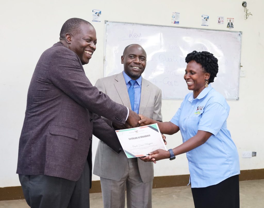 Prof. Tonny Oyana and Mr. Lawrence Sanyu award a certificate of attendance to the College Accountant CPA Franco Mugyema Angida. CoCIS, Makerere University, Kampala Uganda.