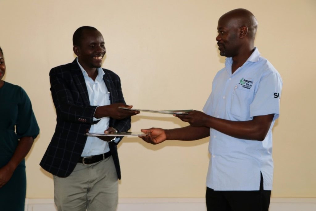 AFRISA Head of Secretariat, Mr. Felix Okello (Left) and the National Director Scripture Union Uganda, Mr. Dickens Zziwa Ssenyonjo (Right) exchange the signed partnership agreements after the signing ceremony. 