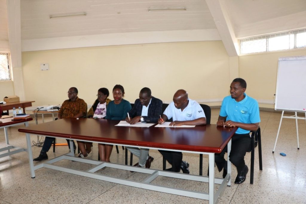 AFRISA Head of Secretariat, Mr. Felix Okello (3rd Right) and the National Director Scripture Union Uganda, Mr. Dickens Zziwa Ssenyonjo (2nd right) signing the partnership agreement during the signing ceremony, held at the Centre for Biosecurity and Global Health, CoVAB on 14th April 2023.  