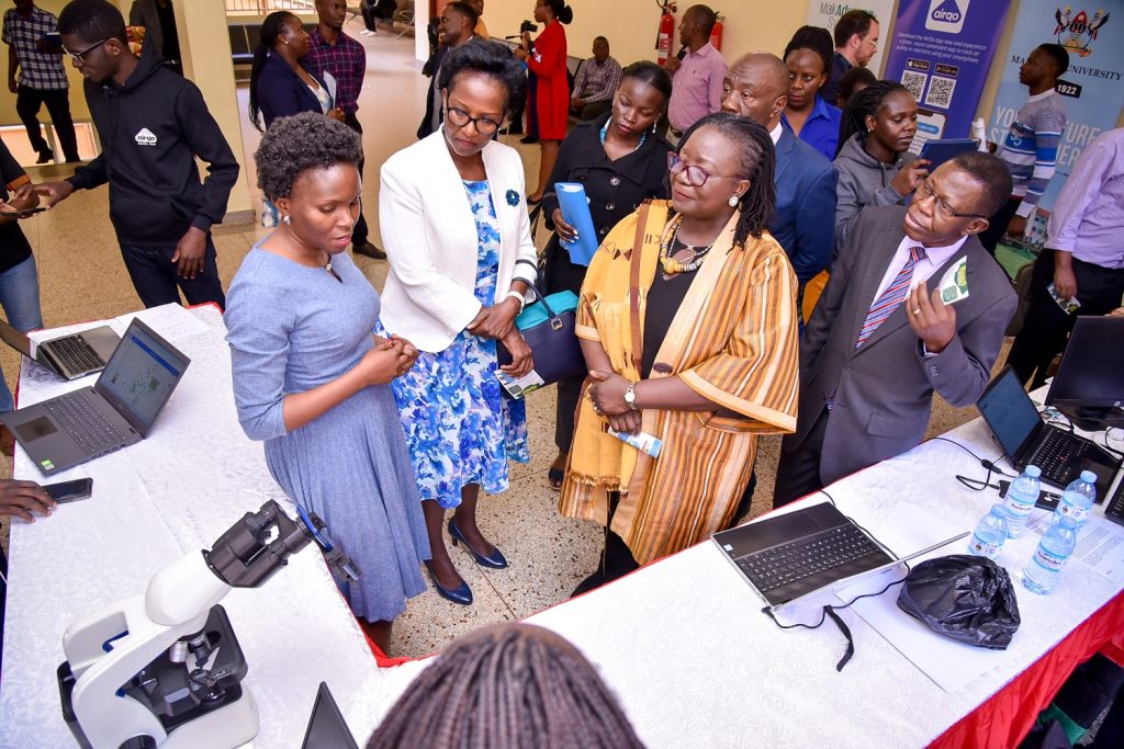 L-R: Dr. Rose Nakasi explains her innovation of the Artificial Intelligence (AI)-based detection of Malaria in blood samples using a smart phone to Mrs. Lorna Magara, Ms. Elsie Attafuah, Prof. Buyinza Mukadasi and other officials, Frank Kalimuzo Central Teaching Facility, Makerere University, Kampala Uganda. 