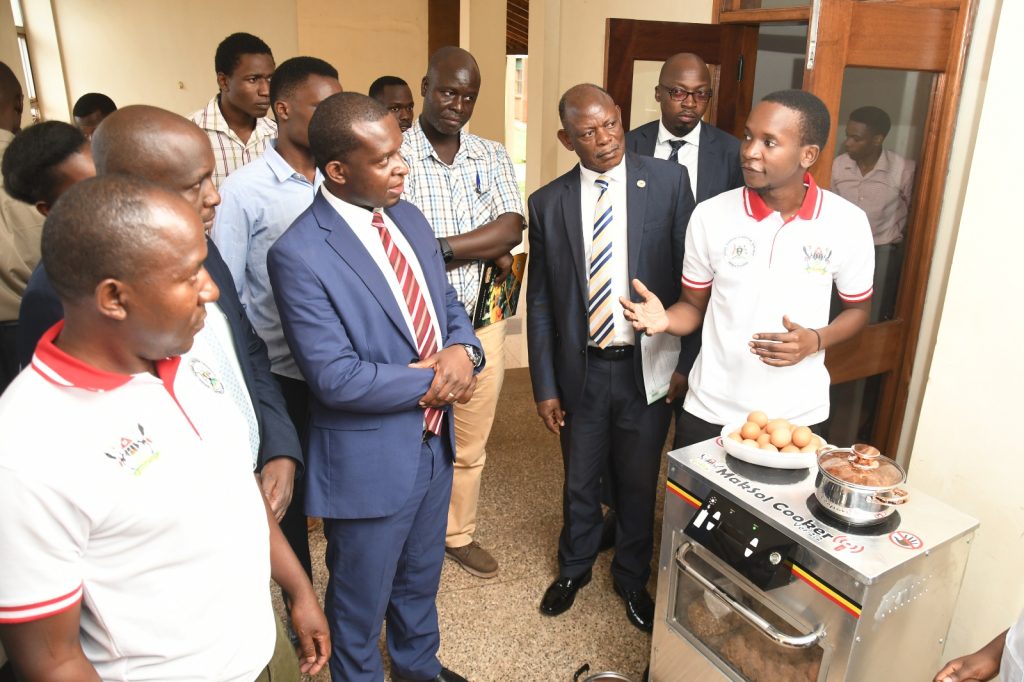 A member of the research team demonstrates how the MakSol Cooker works. School of Food Technology, Nutrition and Bioengineering Conference Hall, CAES, Kampala Uganda.