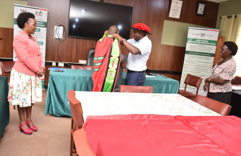 Dr. Babweteera (2nd R) hands over the Dean's Academic gown to Dr. Twinomuhangi. School of Forestry, Environmental and Geographical Sciences (SFEGS), College of Agricultural and Environmental Sciences (CAES), Makerere University, Kampala Uganda. East Africa.