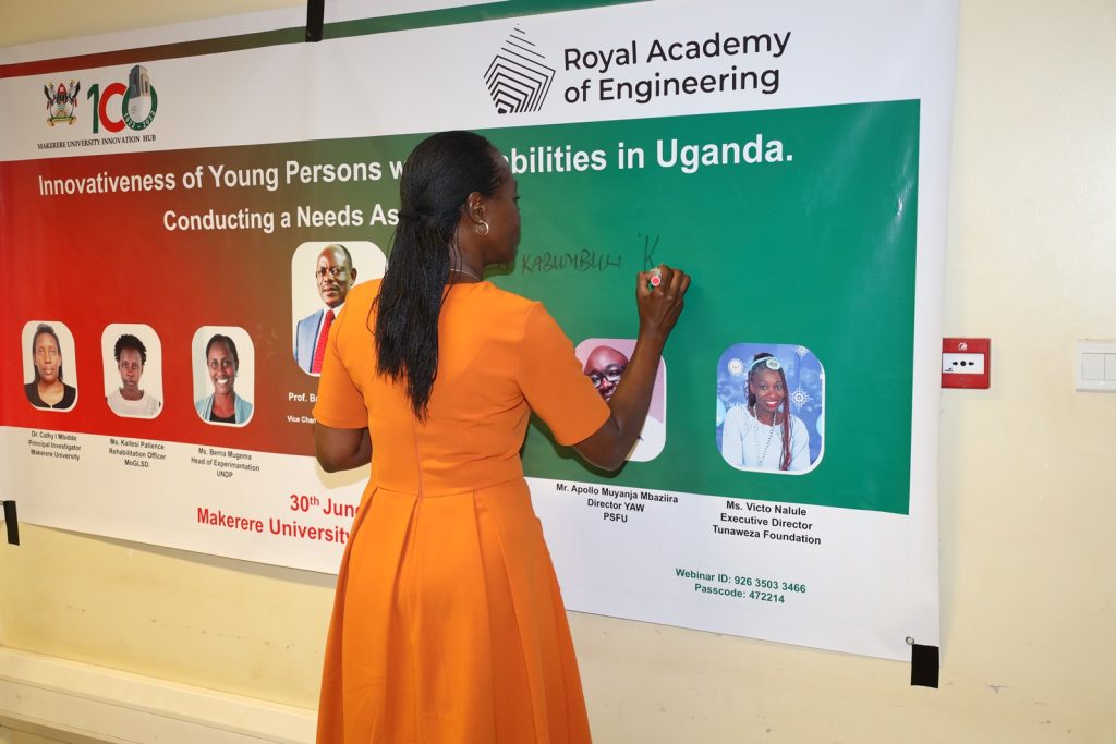 Mrs. Winifred Kabumbuli signs the banner at the launch. Makerere Innovation Hub, Yusuf Lule Central Teaching Facility, Makerere University, Kampala Uganda.