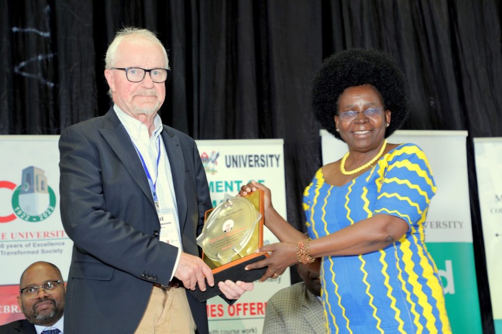 Hon. Dr. Monica Musenero Masanza (Right) presents the award to Prof. Leif Abrahamsson (Left) during the opening ceremony of the joint conference. Yusuf Lule Central Teaching Facility, Makerere University, Kampala Uganda.
