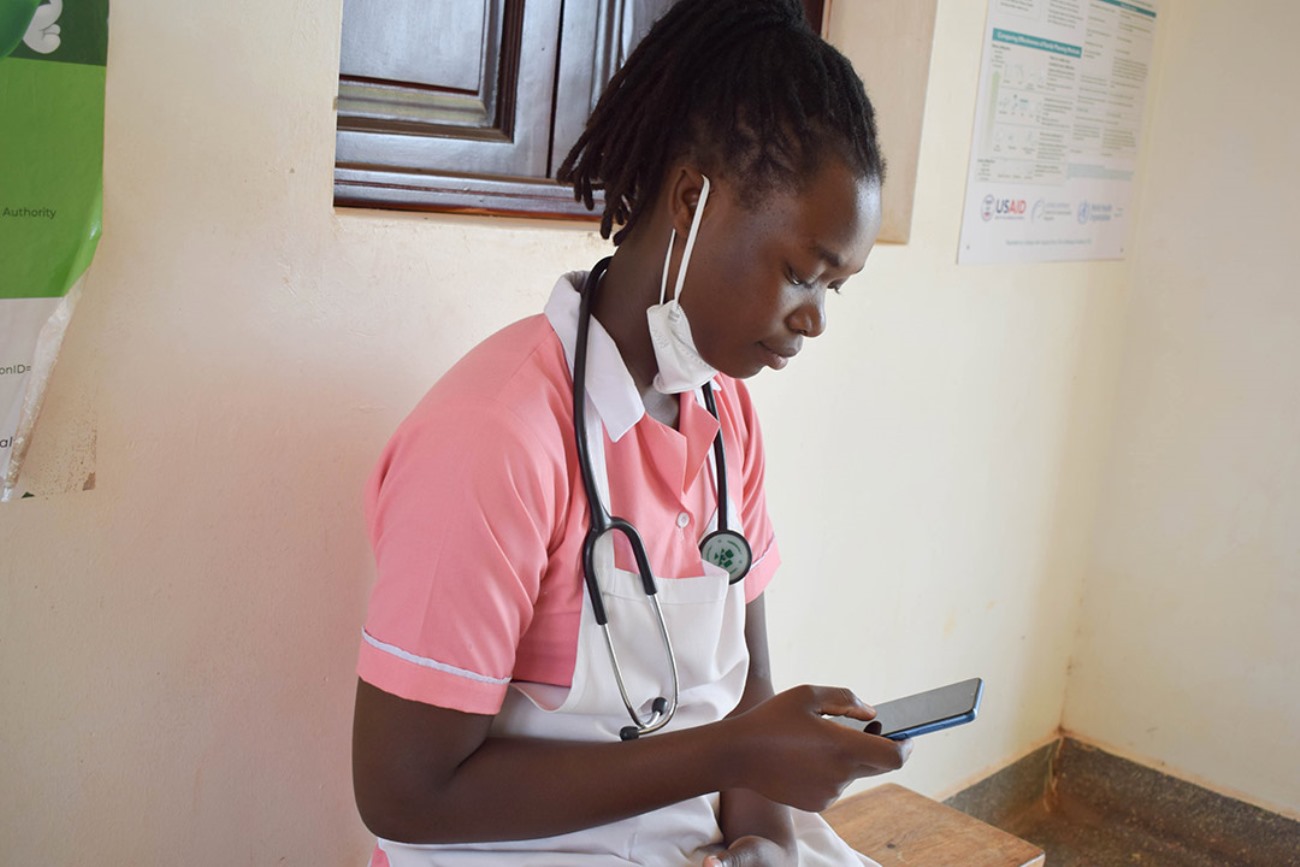 A nurse scrolls through her smartphone. Photo: DHPI-R, MakSPH, CHS, Makerere University, Kampala Uganda, East Africa.