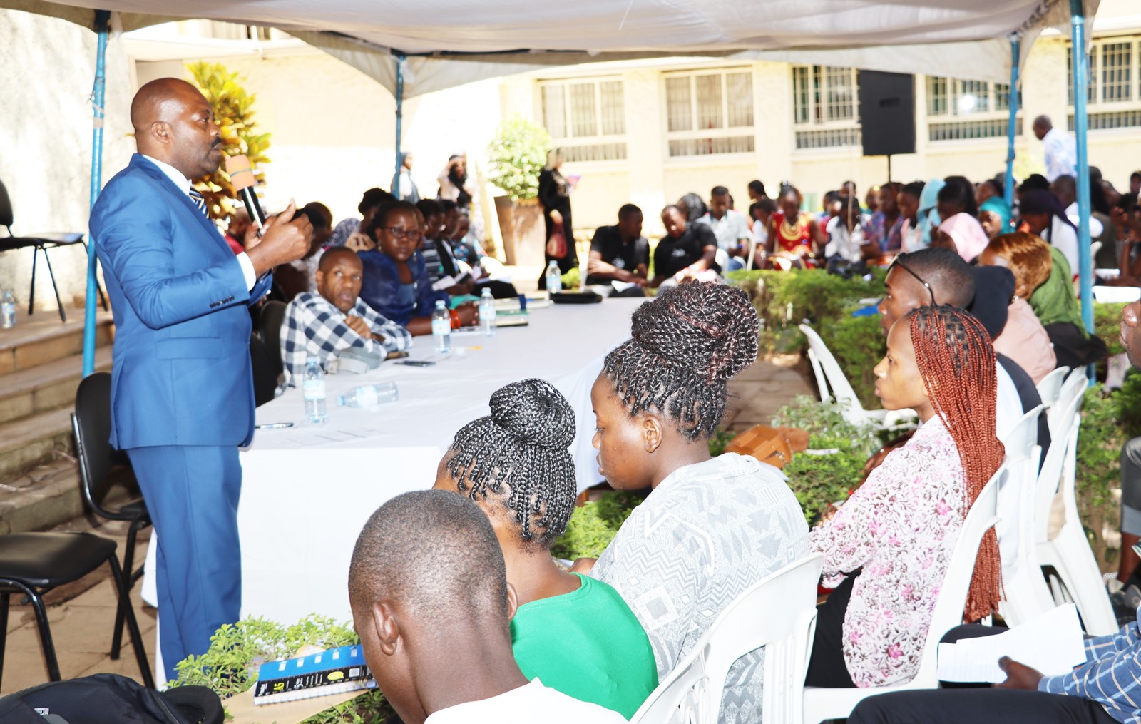 The College Registrar, Mr. Vincent Abigaba (Standing) addresses freshers during the orientation at the Arts Quadrangle, College of HUmanities and Social Sciences (CHUSS). Makerere University, Kampala Uganda. East Africa.