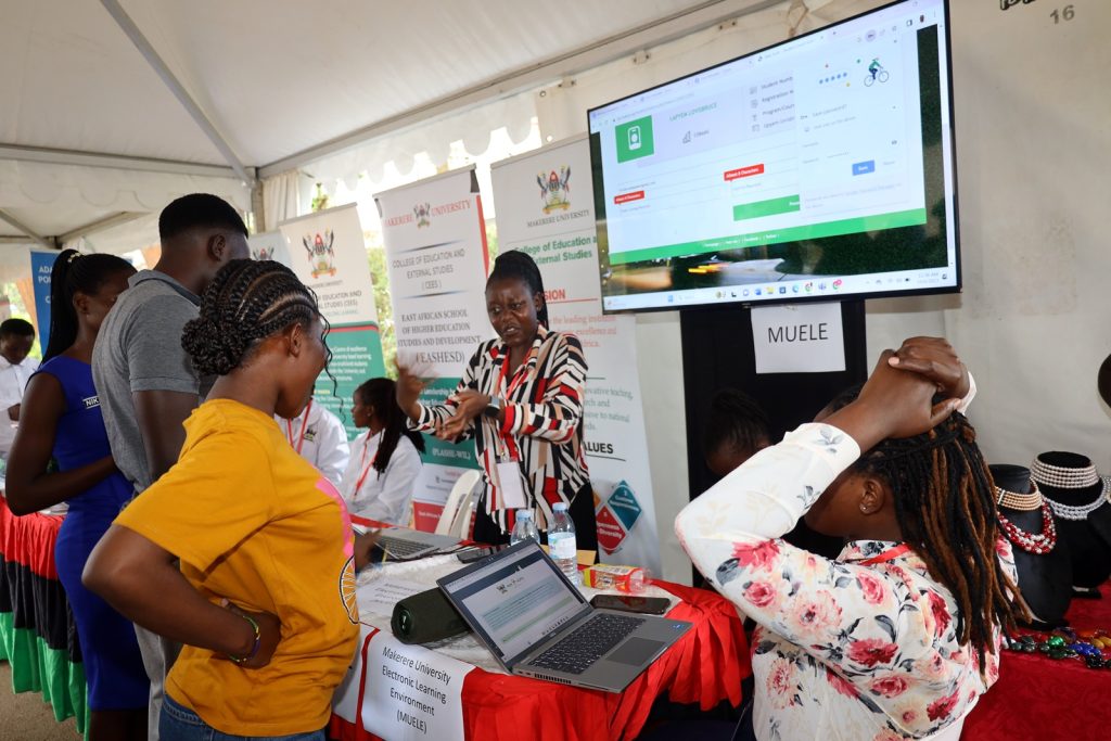 An exhibitor talks to visitors about the Makerere University E-Learning Environment (MUELE). Youth and Innovation Expo, 6th-7th October 2023, Makerere University, Kampala Uganda, East Africa.