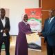 The Director of Research and Graduate Training and Principal Investigator of the PIM Centre of Excellence, Prof. Edward Bbaale (Right) presents a certificate to Ms. Saidat Bawomya from the National Planning Authority (Centre) as another official witnesses.