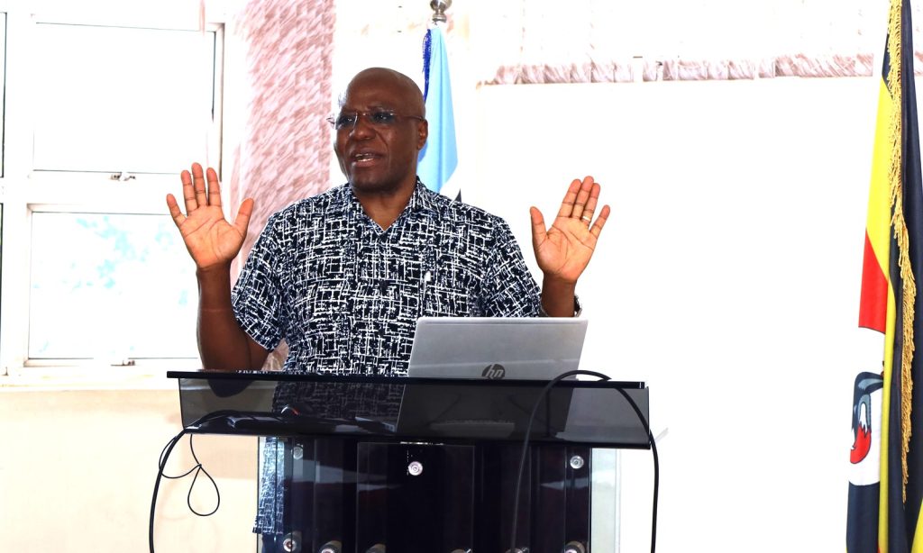 Manager IPMO Goddy Muhumuza presenting during the meeting. Conference Hall, Level 4, Block A, College of Computing and Information Sciences (CoCIS), Makerere University, Kampala Uganda, East Africa.