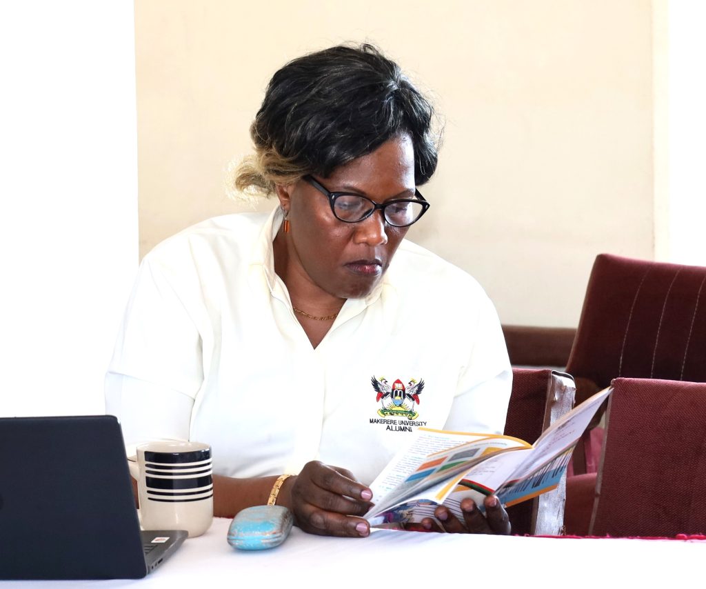 Dr. Joyce Bukirwa Muwanguzi of CoCIS reading the Innovation Hub and Property Management Office brochure. Conference Hall, Level 4, Block A, College of Computing and Information Sciences (CoCIS), Makerere University, Kampala Uganda, East Africa.