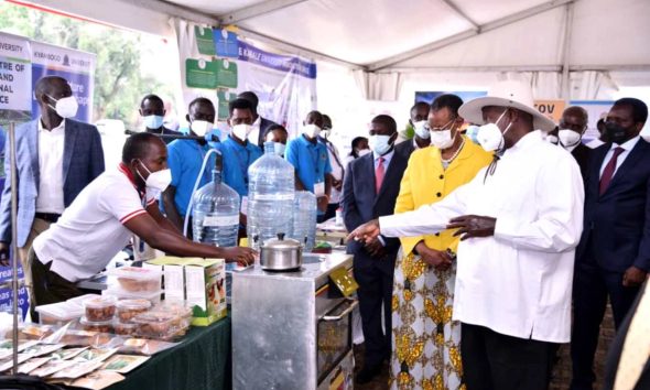 President Yoweri Museveni and First Lady Hon. Janet Museveni listen to Dr. Peter Tumutegyereize (Left) explain how the Mak Solar Cooker works. Photo: Courtesy/NCHE@20, Kololo Ceremonial Grounds. Kampala, Uganda, East Africa.