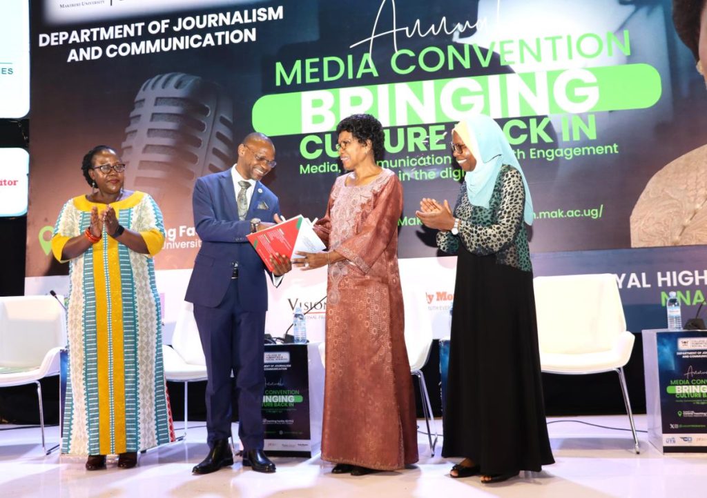 Prof. Umar Kakumba (2nd Right) presents a gift to the Nnabagereka represented by Ms. Judy Kamanyi. Annual Media Convention, 12th October 2023, Yusuf Lule Central Teaching Facility Auditorium, Makerere University, Kampala Uganda, East Africa.