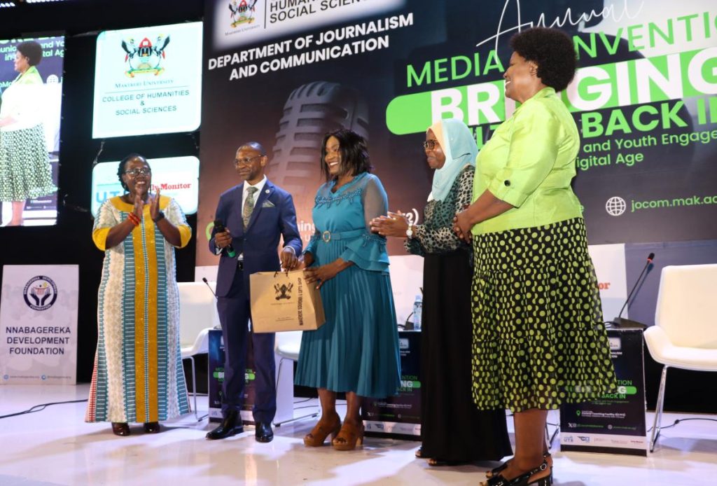 Prof. Umar Kakumba (2nd Left) presents Mak souvenirs to keynote speaker Prof. Elizabeth Lubinga. Annual Media Convention, 12th October 2023, Yusuf Lule Central Teaching Facility Auditorium, Makerere University, Kampala Uganda, East Africa.