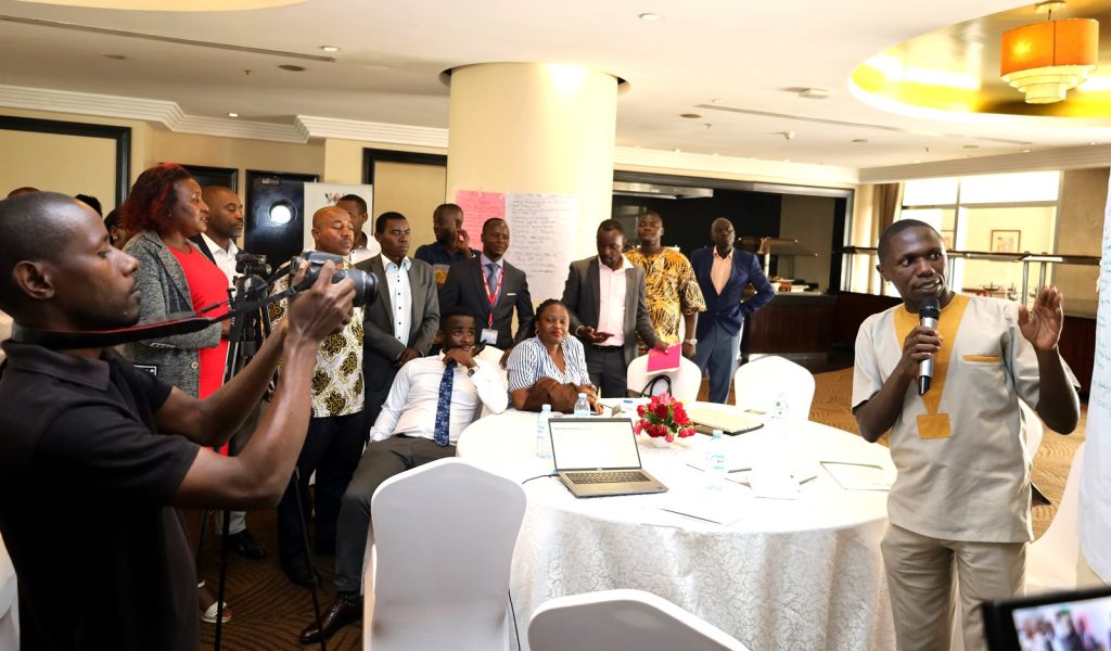 One of the male participants (Right) presenting feedback from the group discussions. Makerere EfD Stakeholders Meeting, Transitioning from Biomass to Clean Energy Sources, 17th November 2023, Kampala Sheraton Hotel, Uganda, East Africa.
