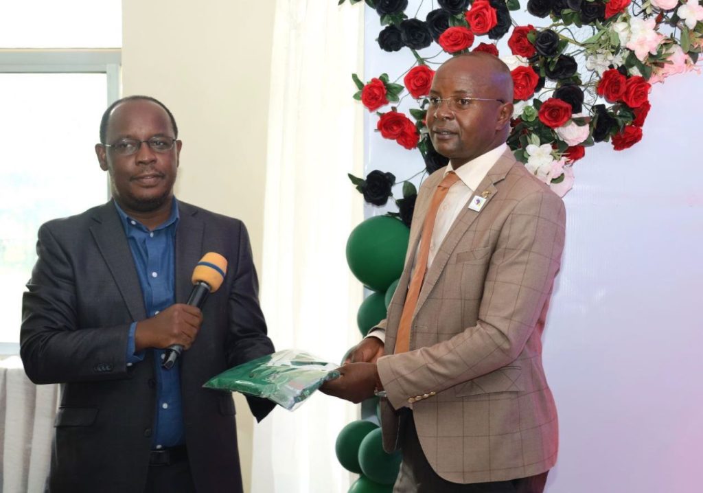 Dr. Peter Nabende giving a gift to Prof. Edward Bbaale after the closing ceremony. EASLIS@60 Luncheon, 10th November 2023, Big Lab 2, Block B, College of Computing and Information Sciences (CoCIS), Makerere University, Kampala Uganda, East Africa.