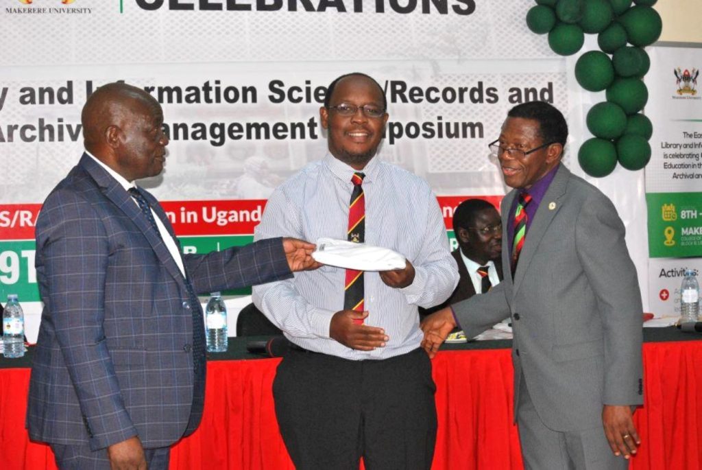 Dr. Peter Nabende (C) receiving the gift from the Chief Guest Hon Muruli Mukasa (L) and Prof. Buyinza Mukadasi (R). EASLIS@60 Conference, 8th-10th November 2023, Big Lab 2, Block B, College of Computing and Information Sciences (CoCIS), Makerere University, Kampala Uganda, East Africa.