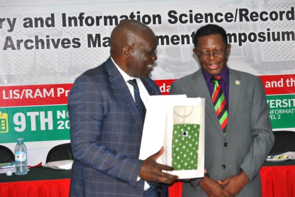 Hon. Muruli Mukasa (Left) after receiving a gift from Prof. Buyinza Mukadasi (Right). EASLIS@60 Conference, 8th-10th November 2023, Big Lab 2, Block B, College of Computing and Information Sciences (CoCIS), Makerere University, Kampala Uganda, East Africa.