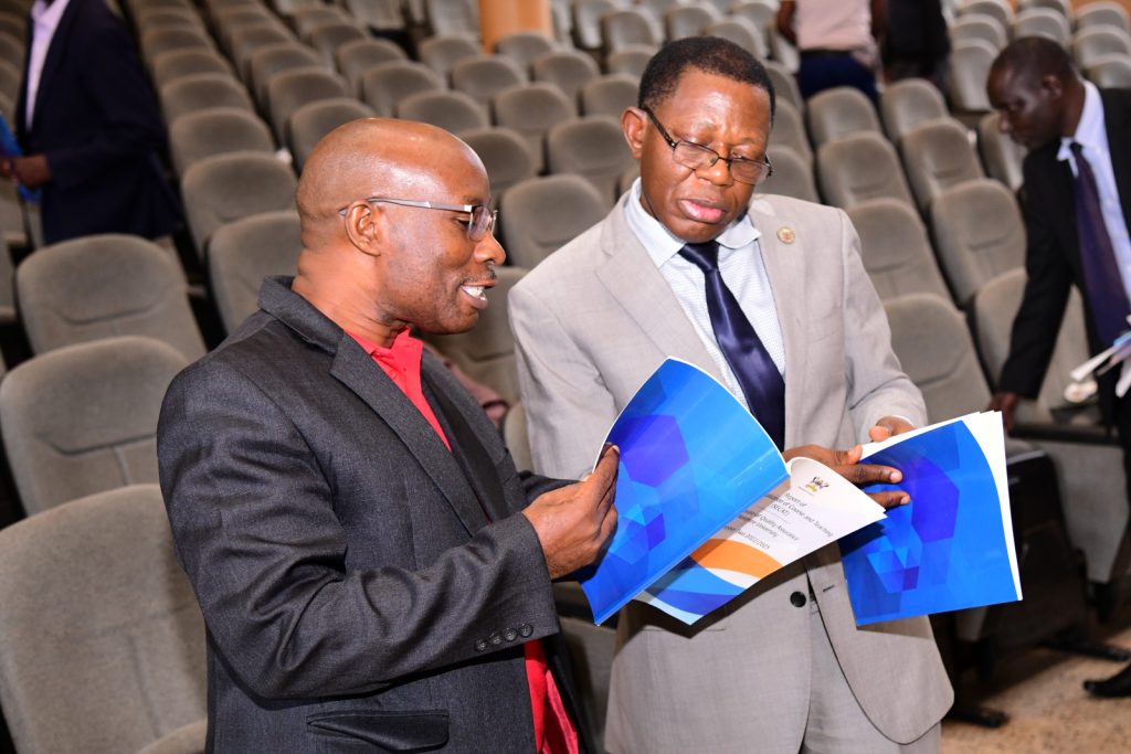 The Academic Registrar-Prof. Buyinza Mukadasi (Right) and Dean School of Biosciences, CoNAS (Left) discuss sections of the report. Launch of SECAT Report for Semester Two 2022/2023 by the Quality Assurance Director, 24th November 2023, Yusuf Lule Central Teaching Facility Auditorium, Makerere University, Kampala Uganda, East Africa.