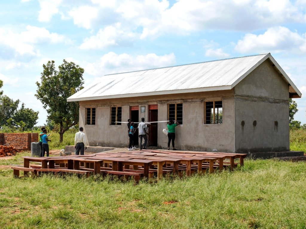 The new classroom block and desks that were donated by the Scholars and Alumni of Mastercard Foundation. Makerere University Mastercard Foundation Scholars and Alumni Annual Day of Community Service (Giveback), 2nd December 2023, Achukudu Community Primary School, Napak District, Karamoja, Uganda, East Africa.