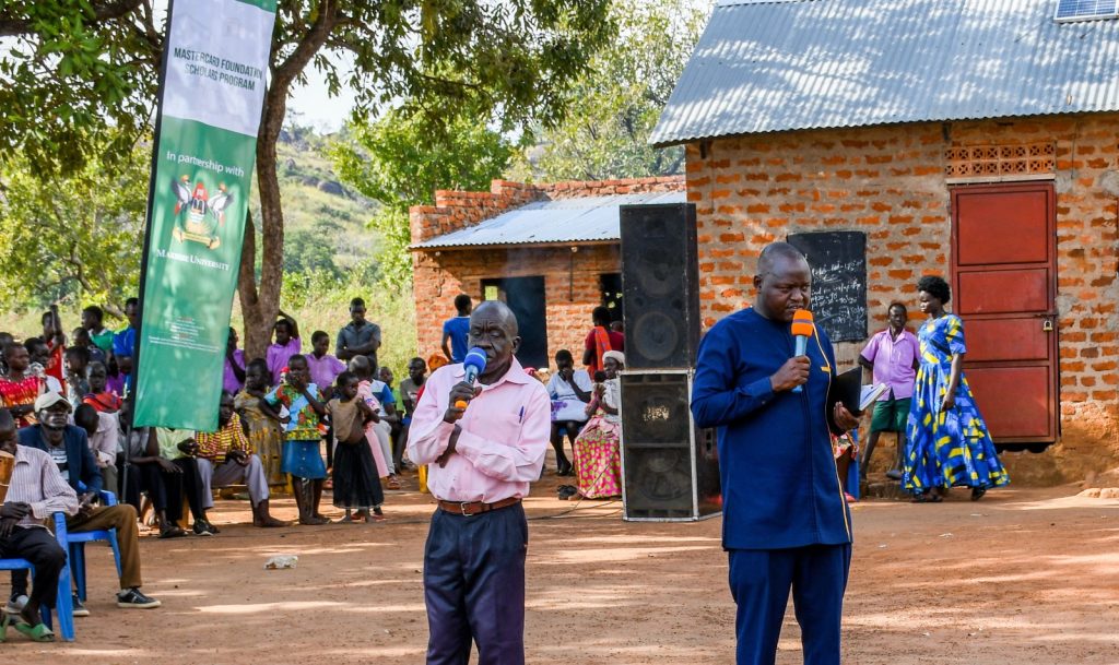 Hon. John Bosco Ngoya, the area MP (Right) who was the chief guest, addressing the gathering. Makerere University Mastercard Foundation Scholars and Alumni Annual Day of Community Service (Giveback), 2nd December 2023, Achukudu Community Primary School, Napak District, Karamoja, Uganda, East Africa.