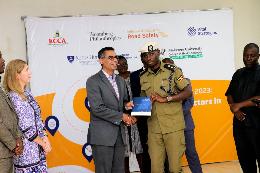 Dr. Abdulgafoor Bachani, Director of JH-IIRU hands over the Kampala Summary Status Report to SP. Michael Kananura, spokesperson, Traffic and Road Safety Directorate, Uganda Police Force during the launch at Hotel Africana on Tuesday, January 16, 2024. Photo by Davidson Ndyabahika. Makerere University School of Public Health, Johns Hopkins International Injury Research Unit, KCCA, Vital Strategies launch of Status Summary Report 2023; Road Risk Factors for Kampala, Uganda, 16th January 2024, Hotel Africana, Kampala Uganda, East Africa.