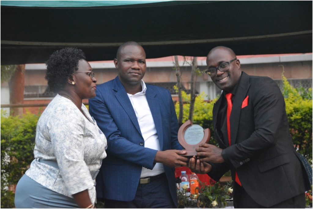 Dr. Stephens Kisaka (R) getting his plaque. CoVAB farewell for outgoing staff, 19th January 2024, Ruth Keesling Gardens, College of Veterinary Medicine, Animal Resources and Biosecurity (COVAB), Makerere University, Kampala Uganda, East Africa.