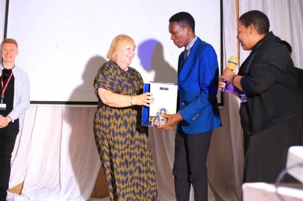 Shafik Senkubuge receives a gift from NTU's Professor Linda Gibson during the 18th Annual MUEHSA scientific conference. Yusuf Lule Central Teaching Facility Auditorium, Makerere University, Kampala Uganda, East Africa.