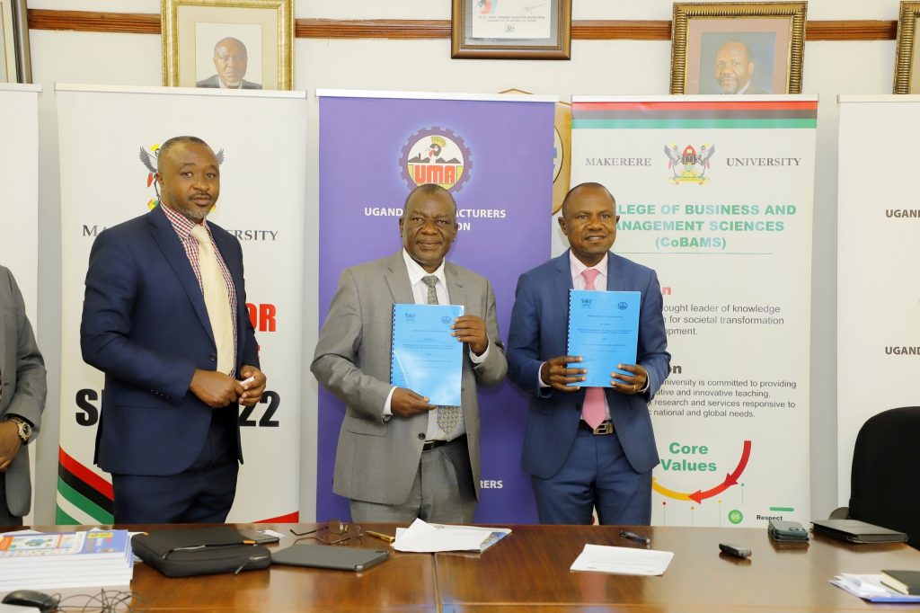 Prof. Eria Hisali and Mr. Deo JB Kayemba show off the signed MoU as another witnesses. Makerere University College of Business and Mangement Sciences (CoBAMS)-Uganda Manufacturers Association (UMA) Industrial Research MoU Signing Ceremony, 27th February 2024, Nakawa, Kampala Uganda, East Africa.