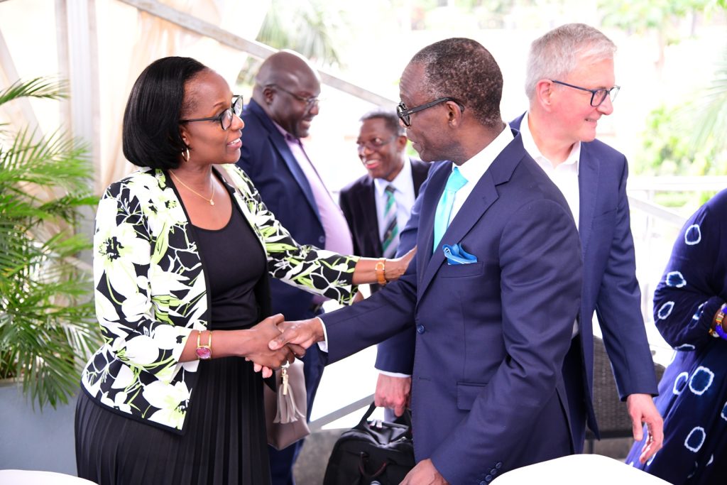 Mrs. Lorna Magara (Left) shakes hands with Dr. Opiyo Oloya as Dr. Alan Shepard (Rear Right) and other officials interact. 21st March 2024, Golden Tulip Hotel, Kampala Uganda, East Africa.