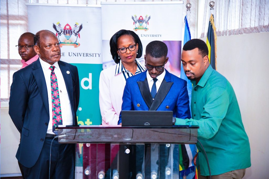 Mrs. Lorna Magara (2nd Left) and Prof. Barnabas Nawangwe (Left) witness as Hon. Emojong Kisaija Harman (2nd Right) assisted by Mr. Joshua Muhumuza (Right) launches the Student Attendance Management System (SAMS). Launch of the staff and students attendance management system by Chairperson of Council, Mrs. Lorna Magara, 3rd May 2024, Conference Room, Level 4, College of Computing and Information Sciences (CoCIS), Makerere University, Kampala Uganda, East Africa.