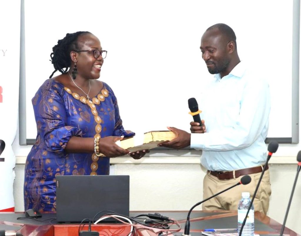 Prof. Ahikire receives a gift from CHUSS Deans presented by Dr. Baluku Martin. Prof. Josephine Ahikire Hands Over College of Humanities and Social Sciences (CHUSS) Leadership to Assoc. Prof. Helen Nambalirwa Nkabala, 31st May 2024, CHUSS Smart room, Makerere University, Kampala Uganda, East Africa.