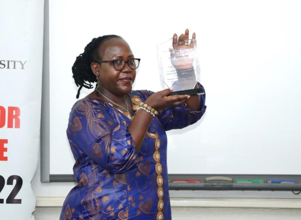 Prof. Ahikire displays the plaque from the college presented to her in recognition of her exemplary service. Prof. Josephine Ahikire Hands Over College of Humanities and Social Sciences (CHUSS) Leadership to Assoc. Prof. Helen Nambalirwa Nkabala, 31st May 2024, CHUSS Smart room, Makerere University, Kampala Uganda, East Africa.