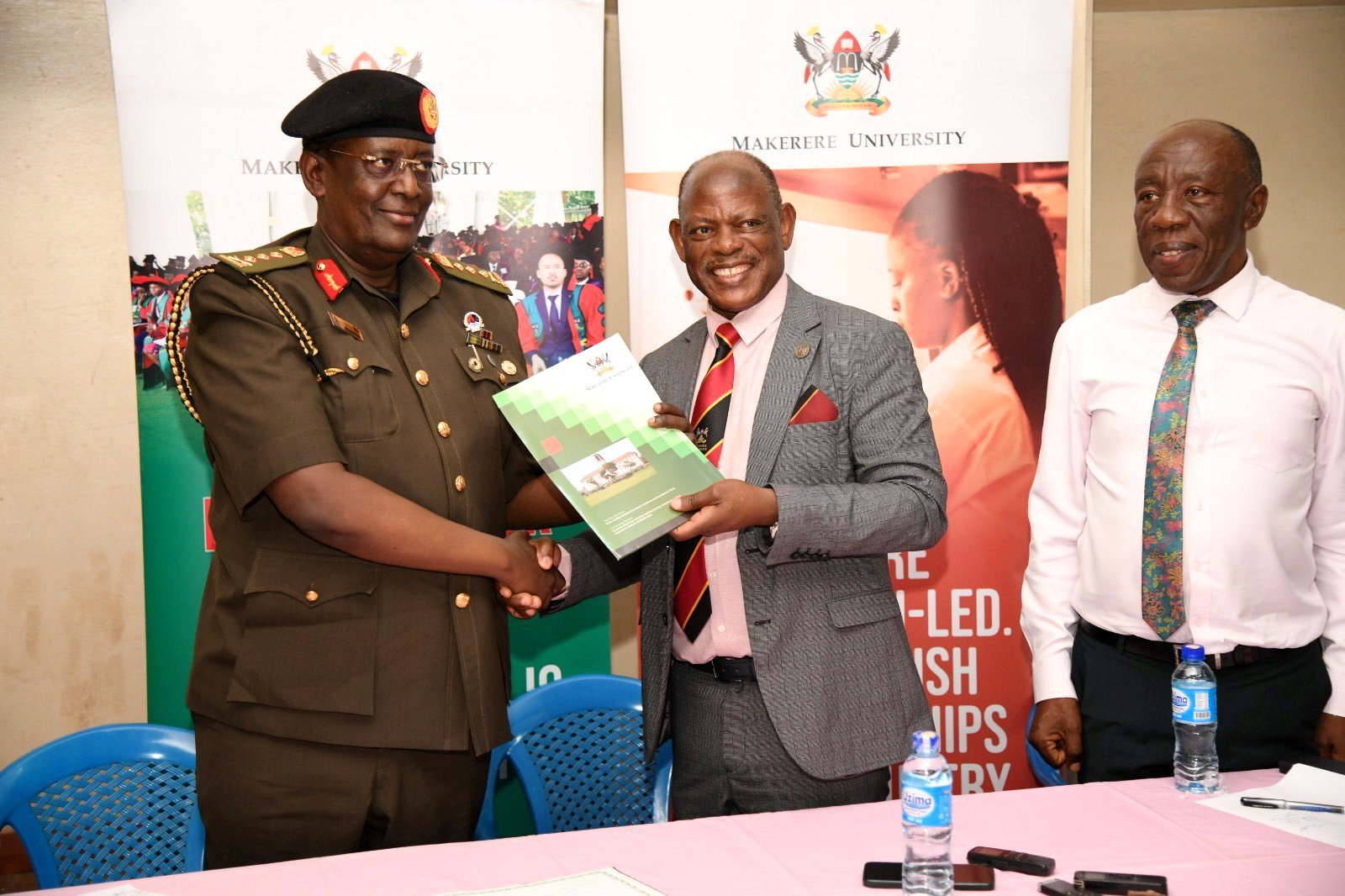 The Vice Chancellor, Prof. Barnabas Nawangwe (Centre) hands over a file to NEC Managing Director and CEO, Lieutenant General James Mugira (Left) as Ag. DVCFA, Prof. Henry Alinaitwe (Right) witnesses on 31st May 2024. Site Handover for the proposed rehabilitation of Mary Stuart Hall, Mary Stuart Road, Makerere University, Kampala Uganda, East Africa.