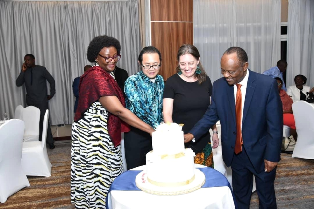 Makerere University School of Public Health (MakSPH) Dean, Prof Rhoda Wanyenze (Left), MoH Director General, Dr. Henry Mwebesa (Right) and other stakeholders join Dr. Amy Boore (2nd Right) to cut cake at her farewell event. Golden Tulip Hotel, Kampala Uganda, East Africa.