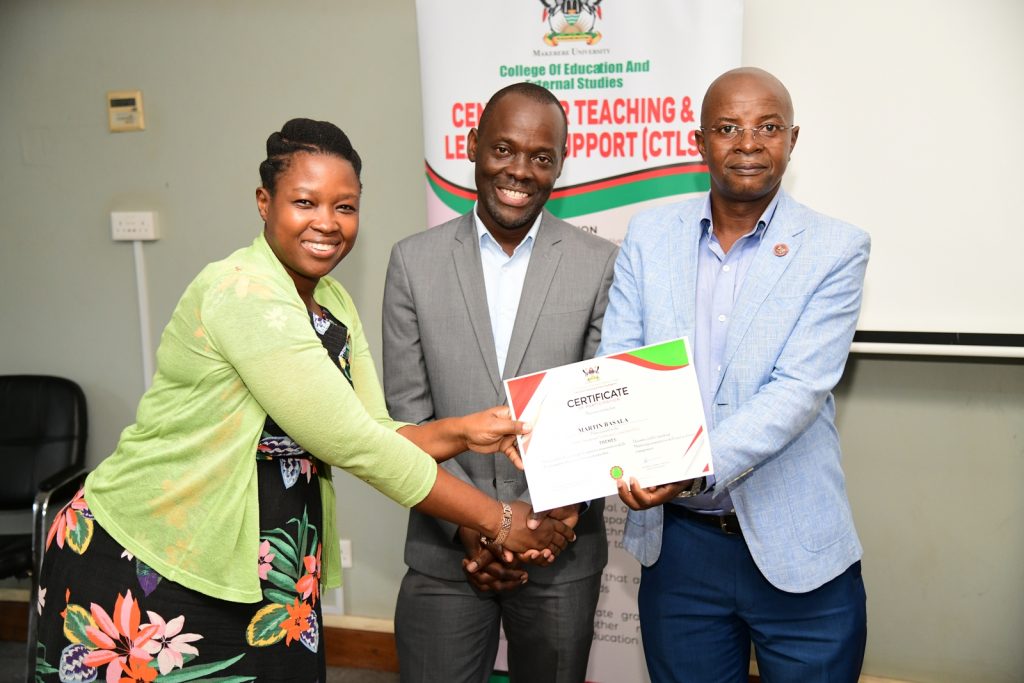 Prof. Bbaale (Right) and Prof. Mulumba (Centre) present a certificate to a female participant. Centre for Teaching and Learning Support (CTLS), College of Education and External Studies (CEES), Public Speaking Short Course for Twenty-five officials from the office of the parliamentary budget at the Parliament of Uganda, Certificate Award Ceremony, 17th May 2024, Senate Conference Hall, Makerere University, Kampala Uganda, East Africa.