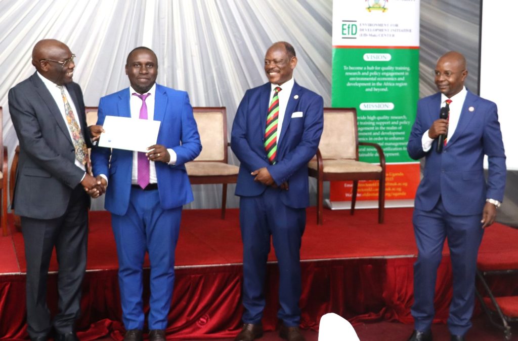 A graduating IGE fellow receiving a certificate from Hon. Okaasai Opolot witnessed by Prof. Nawangwe and Prof. Bbaale. EfD Uganda, Makerere University, Kampala Uganda, East Africa graduation of Third Cohort of the Inclusive Green Economy (IGE) Capacity Building Program Fellows, 7th August 2024, Kampala Sheraton Hotel.