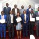 Graduands display their certificates in a group photo with Hon. Okaasai Opolot Sidronius (3rd Left), Prof. Barnabas Nawangwe (4th Right) and Prof. Edward Bbaale (Rear Right). EfD Uganda, Makerere University, Kampala Uganda, East Africa graduation of Third Cohort of the Inclusive Green Economy (IGE) Capacity Building Program Fellows, 7th August 2024, Kampala Sheraton Hotel.