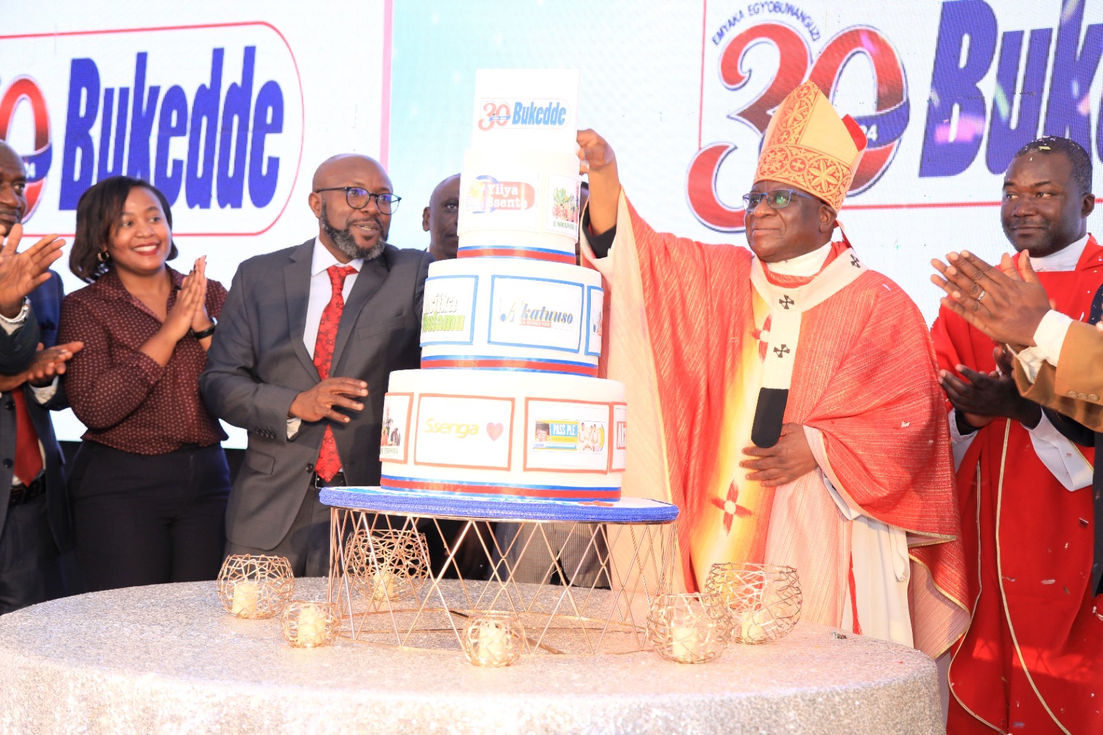 The Archbishop of Kampala, His Grace Paul Ssemogerere (2nd Right) is joined by Vision Group CEO Mr. Don Wanyama (3rd Left) and other officials to cut cake on 29th August 2024. #BukeddeAt30 Celebration Mass, Vision Group Headquarters, Plot 19-21, First Street, Industrial Area, Kampala Uganda, East Africa.