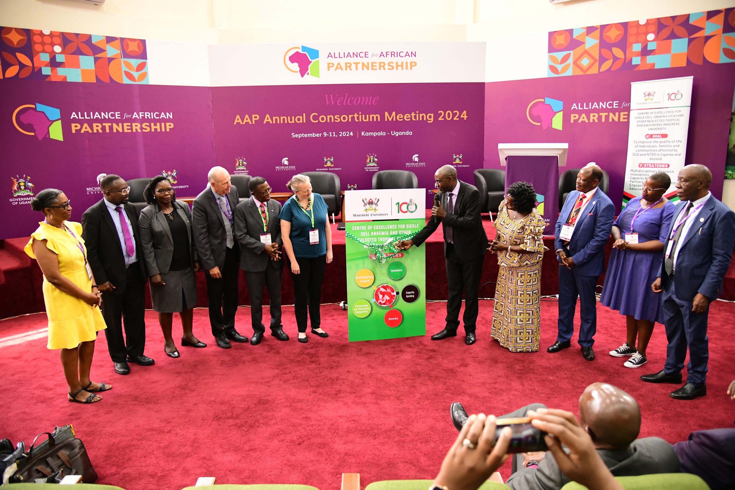 Mr. Muzamil Mukwatampola cuts the tape to officially launched the Centre of Excellence for Sickle Cell Anemia and Other Neglected Tropical Diseases at the Alliance for African Partnership (AAP) of Michigan State University (MSU) Annual Consortium Meeting Launch on 9th September 2024. Alliance for African Partnership (AAP) of Michigan State University (MSU) Annual Consortium Meeting. Hosted by Makerere University in the School of Public Health Conference Hall, Kampala Uganda, East Africa 9th-11th September 2024.