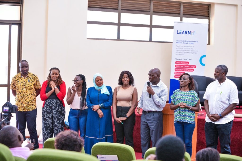 Dr Mukwaya introducing members of the organizing committee. Leiden-Delft-Erasmus East Africa Research Network (LEARN) in collaboration with the Urban Action Lab at Makerere University a workshop to deliberate strategies for mitigating the impacts of climate change in urban centres in the East African Region, Theme: “Resilient Urban Futures: Adapting Livelihoods to Climate Change”, 4th-5th September 2024, School of Public Health Auditorium, Kampala Uganda.