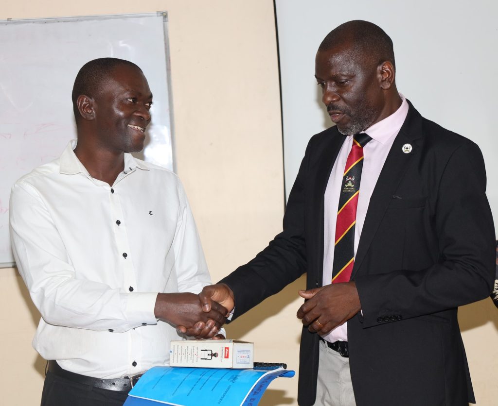 Incoming Dean-Prof. Jude Ssempebwa (Left) receives instruments of power from Outgoing Dean-Dr. Julius Kikooma. East African School of Higher Education Studies and Development (EASHESD), College of Education and External Studies (CEES), Makerere University, Kampala Uganda, East Africa, Deanship Handover, 9th September 2024.