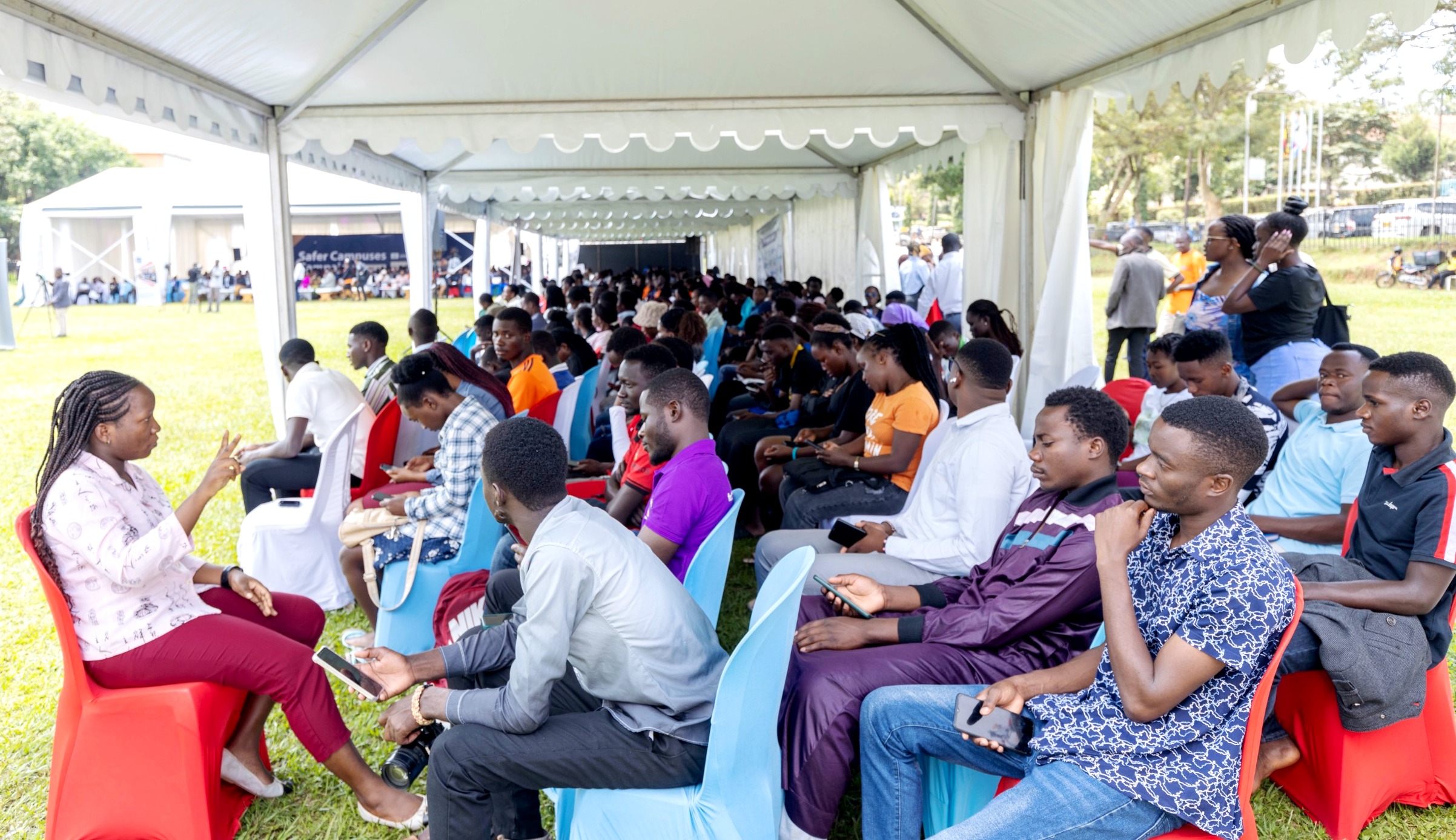 A sign-language interpreter ensures participants with hearing disability follow the proceedings. Launch of the "Safer Campuses Campaign," aimed at shattering the silence surrounding Gender-Based Violence (GBV) in partnership with UNESCO, 4th October 2024, Freedom Square, Makerere University, Kampala Uganda, East Africa.