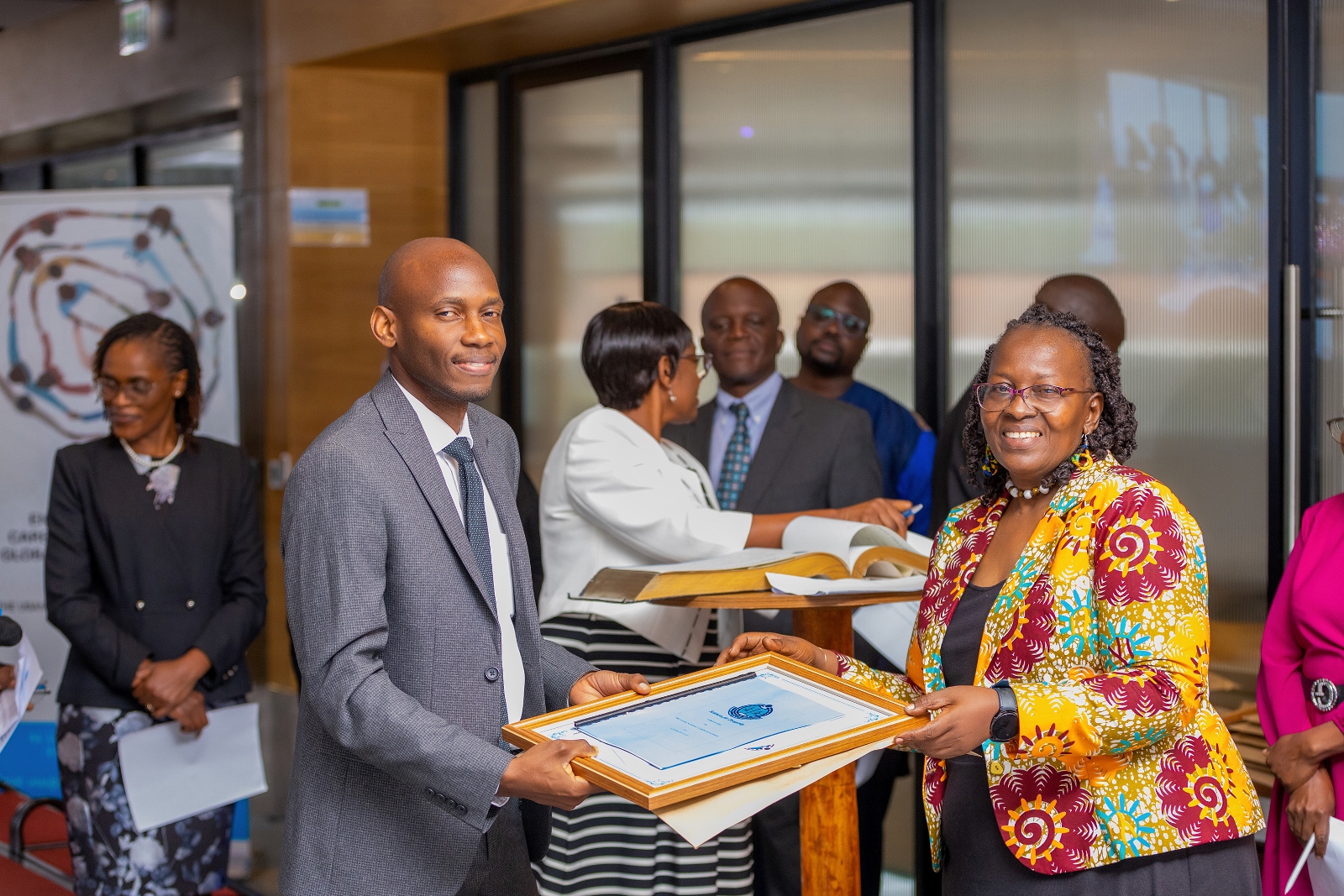 Dr. David Musoke receives a certificate and fellowship membership instruments shortly after oath taking. Four Makerere University School of Public Health (MakSPH) faculty induction into the 2024 Uganda National Academy of Sciences (UNAS) fellowship, 1st November 2024, Four Points by Sheraton, Kampala Uganda, East Africa.