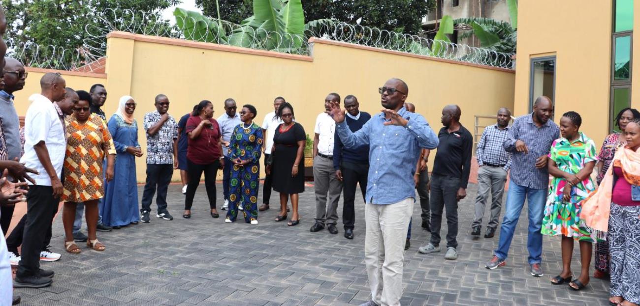 Kalema with staff outside the hotel conducting drills about leadership. Makerere University College of Humanities and Social Sciences (CHUSS) Staff Retreat, 1st-2nd November 2024, Nican Resort Hotel, Seguku Entebbe Road, Kampala Uganda, East Africa.